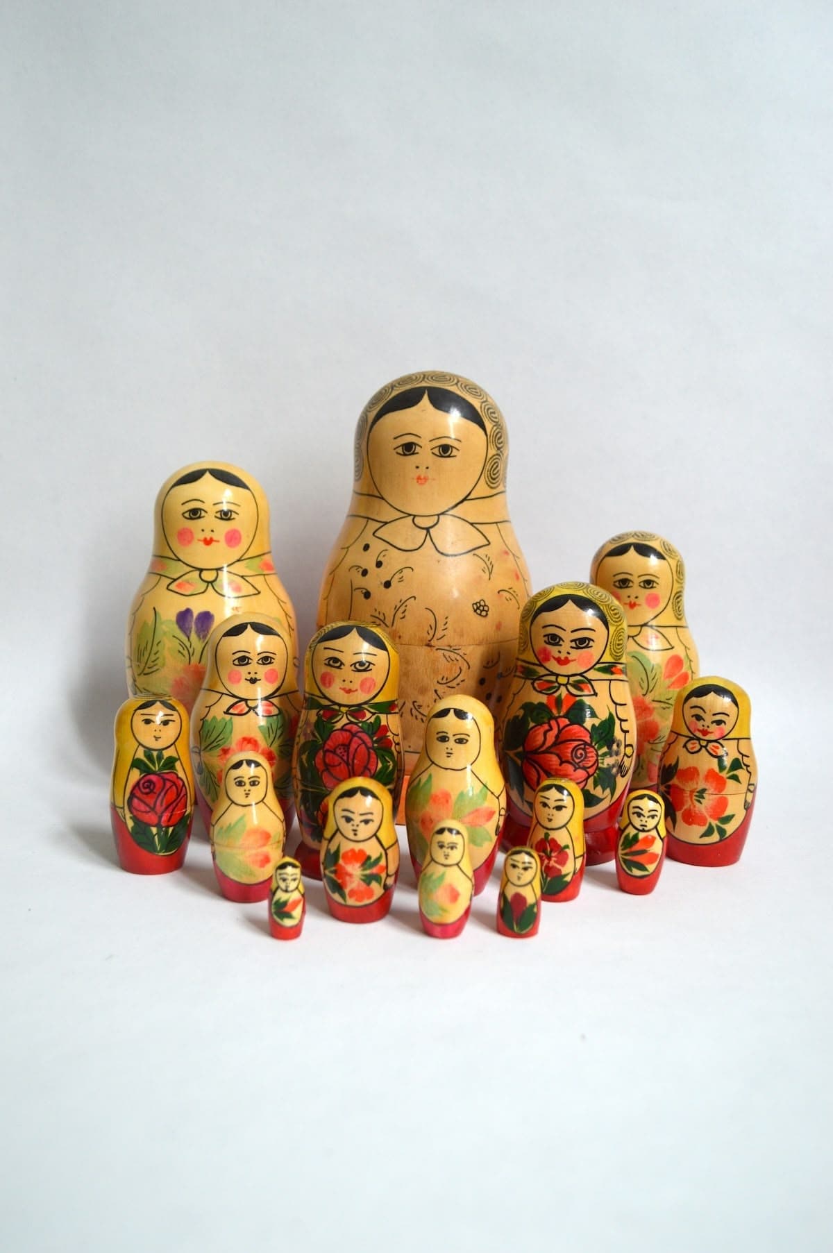 Set of traditional Russian nesting dolls painted with floral designs and faces, arranged in rows from largest to smallest.